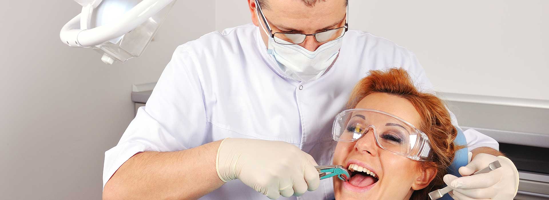 Dentist doing a dental extraction procedure for his patient