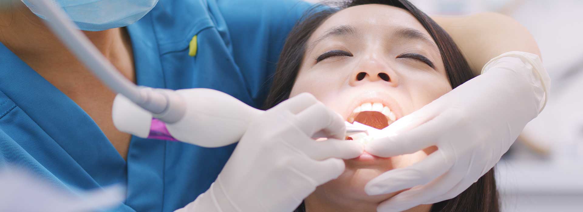 Dentist doing a root planing procedure for her patient